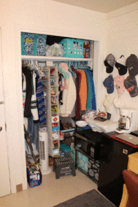 A closet with many ties and clothes hanging on it.