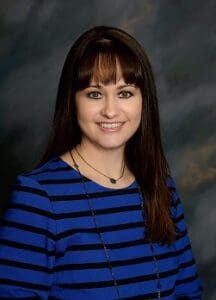 A woman with long hair and blue striped shirt.