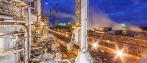 A factory with pipes and lights at night.