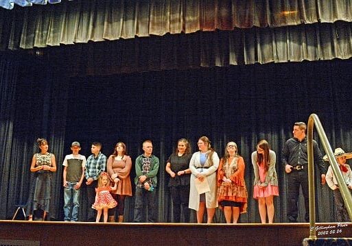 DSC_3536-Performers on stage-sig A group of people standing on stage in front of a curtain.